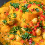 Close-up sweet potato and chickpea curry with coconut milk featuring a title overlay.
