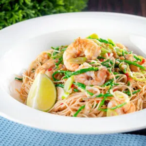 Thai influenced prawn stir fry with samphire and egg noodles and lime wedges.