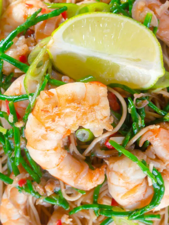 Overhead close-up Thai influenced prawn stir fry with samphire and egg noodles.