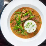 Overhead Thai red beef curry with sugar snap peas and coconut milk sauce.