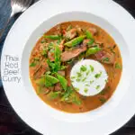 Overhead Thai red beef curry with sugar snap peas and coconut milk sauce featuring a title overlay.