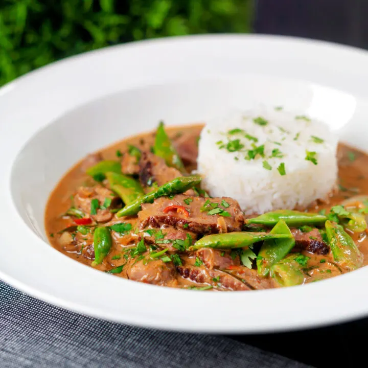 Thai red beef curry with sugar snap peas and coconut milk sauce served with rice.