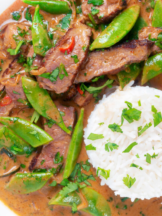 Overhead close-up Thai red beef curry with sugar snap peas and coconut milk sauce.