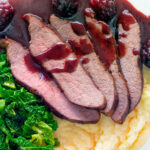 Overhead close-up Wild boar haunch steak with blackberry sauce, cabbage and mashed potato featuring a title overlay.