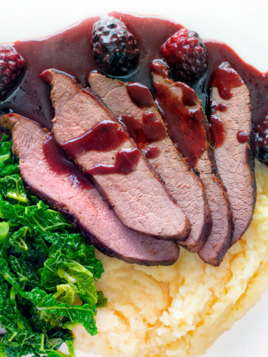 Overhead close-up Wild boar haunch steak with blackberry sauce, cabbage and mashed potato featuring a title overlay.