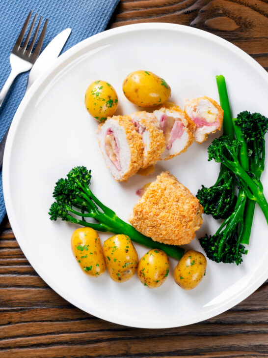 Overhead chicken cordon bleu cooked in an air fryer served with potatoes and broccoli.