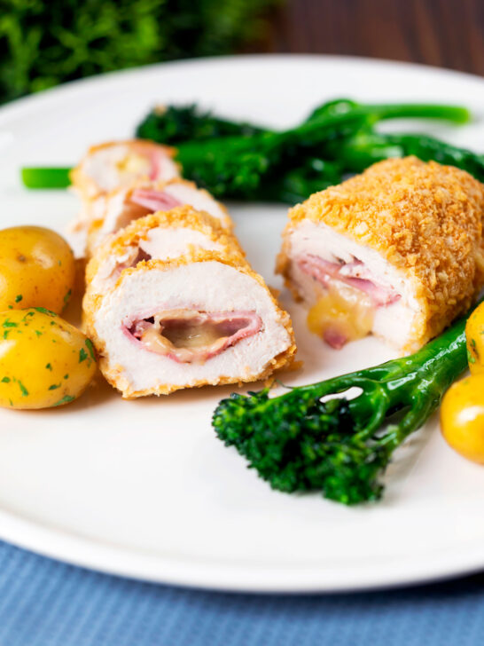 Chicken cordon bleu cooked in an air fryer served with potatoes and broccoli.