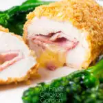 Close-up golden crumbed chicken cordon bleu cooked in an air fryer featuring a title overlay.