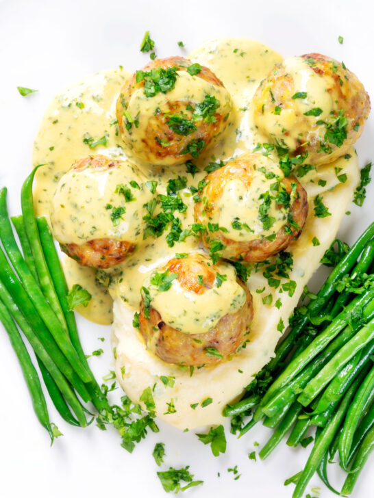 Overhead chicken meatballs with honey, mustard sauce and mashed potato.