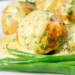 Close-up ground chicken meatballs with honey, mustard sauce and green beans featuring a title overlay.