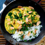 Overhead chicken pasanda yoghurt, coriander and almond curry served with naan bread.