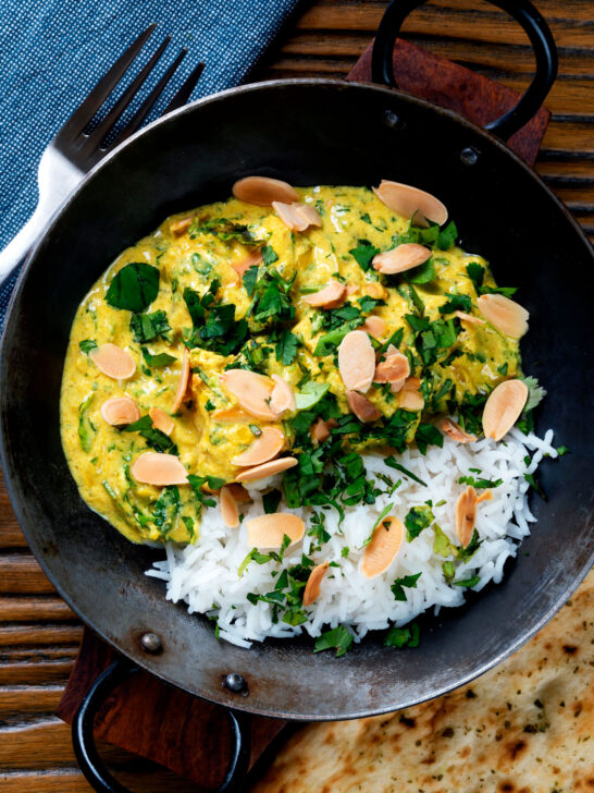 Overhead chicken pasanda yoghurt, coriander and almond curry served with naan bread.