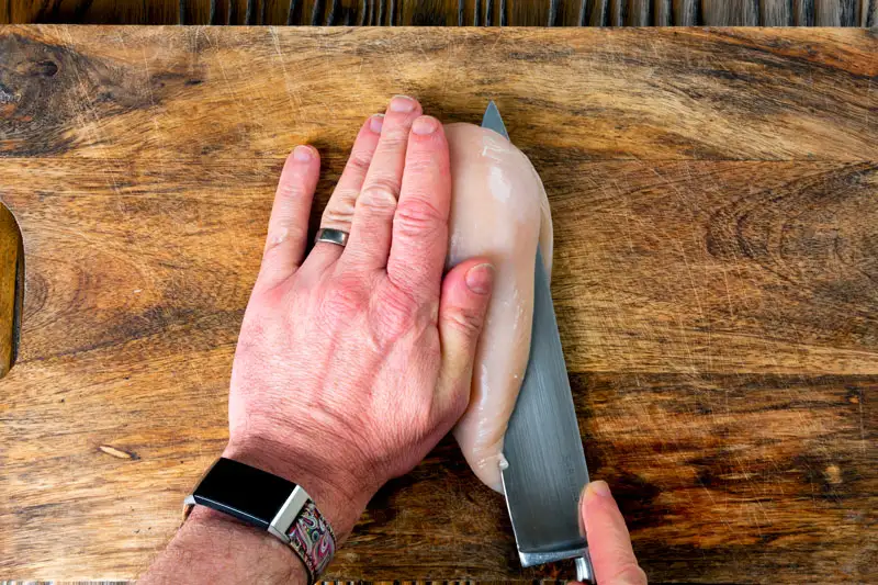 Slicing a chicken breast to butterfly it.