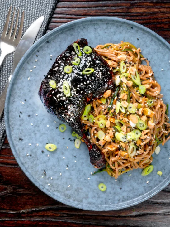 Overhead hoisin baked duck legs with soba noodle salad.