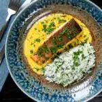 Overhead Indian salmon fillet curry with a yoghurt sauce served with rice.