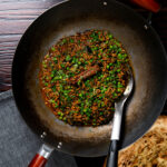 Overhead keema matar curry cooked and served in a wok.