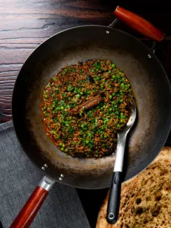 Overhead keema matar curry cooked and served in a wok.