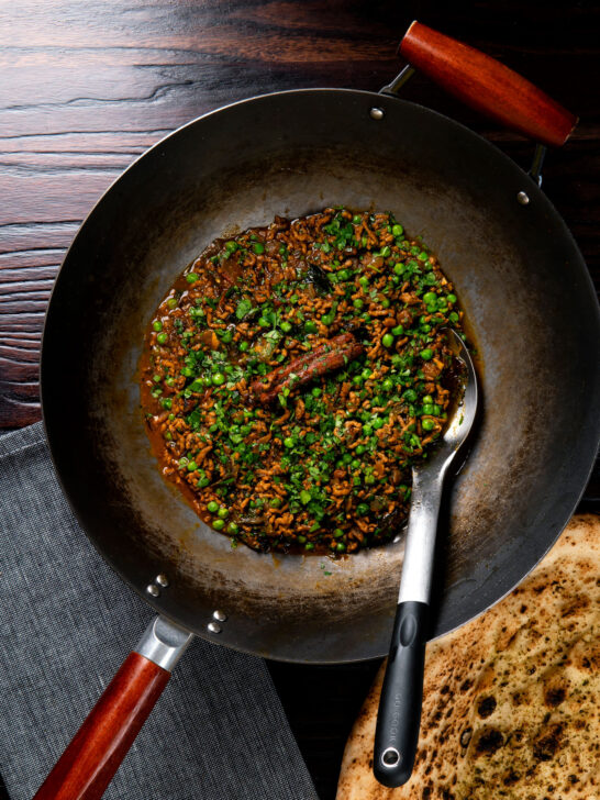 Overhead keema matar curry cooked and served in a wok.