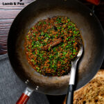 Overhead keema matar curry cooked and served in a wok featuring a title overlay.