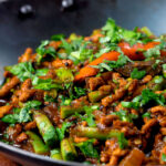 Close-up hot and sour pork mince curry with green beans.
