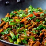 Close-up hot and sour pork mince curry with green beans.