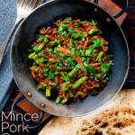 Overhead hot and sour pork mince curry with green beans and naan bread featuring a title overlay.