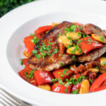 Oven-baked pork loin steaks with chorizo, peppers and beans in a honey glaze.
