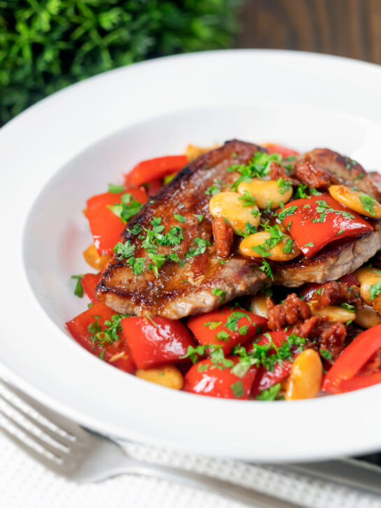 Oven-baked pork loin steaks with chorizo, peppers and beans in a honey glaze.