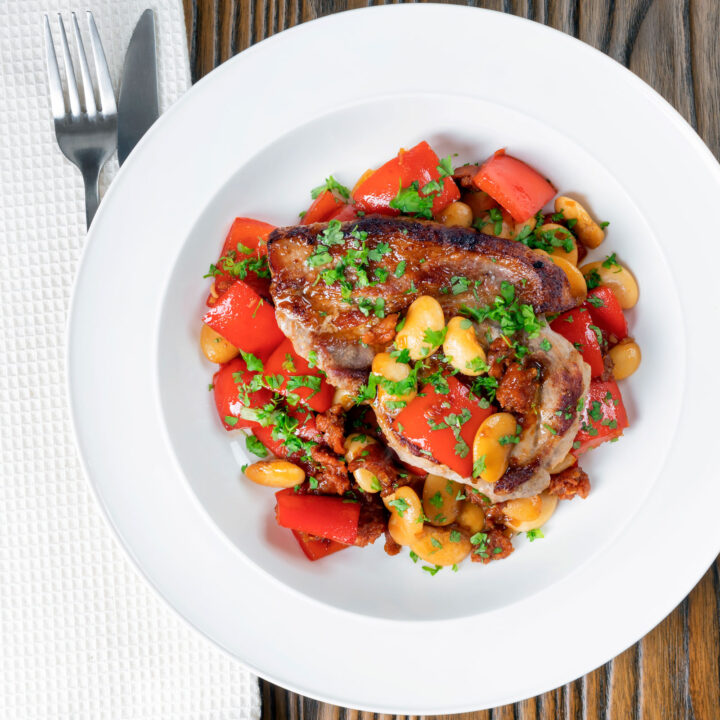 Oven roast pork loin Steaks with a honey glaze, chorizo, peppers and butter beans.