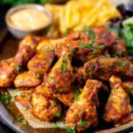 Peri peri chicken wings with fries, spicy mayonnaise and salad featuring a title overlay.