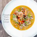 Overhead creamy Thai prawn tom yum soup featuring a title overlay.