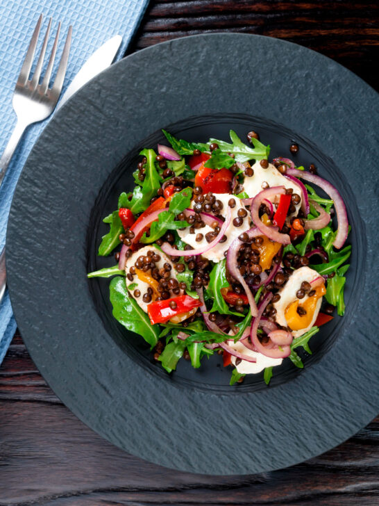 Overhead puy lentil salad with roasted peppers, goat's cheese and rocket.