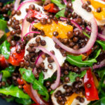Close-up overhead French lentil salad with roasted peppers, goat's cheese and rocket.