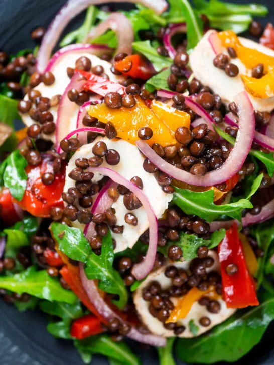 Close-up overhead French lentil salad with roasted peppers, goat's cheese and rocket.