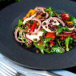 Puy lentil salad with roasted peppers, goat's cheese and rocket featuring a title overlay.