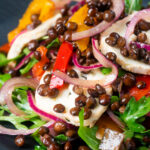 Close-up French lentil salad with roasted peppers, goat's cheese and rocket.