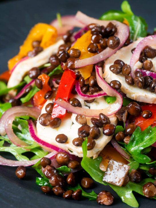 Close-up French lentil salad with roasted peppers, goat's cheese and rocket.