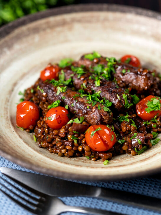 Beef sausage and lentil casserole with cherry tomatoes.