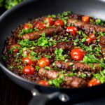 Sausage and lentil casserole with cherry tomatoes in the cooking pan.