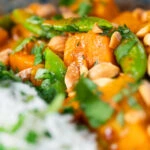 Vegan satay sweet potato curry with peanuts and sugar snap peas.