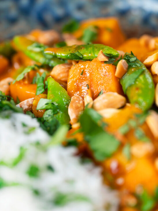 Vegan satay sweet potato curry with peanuts and sugar snap peas.