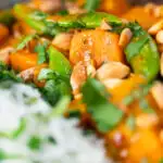 Vegan satay sweet potato curry with peanuts featuring a title overlay.