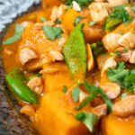 Close-up vegan satay sweet potato curry with a coconut milk sauce.