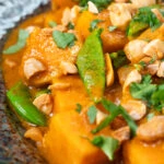Close-up vegan satay sweet potato curry with a coconut milk sauce.