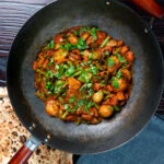 Overhead vegan vegetable bhuna Indian curry served in a wok.