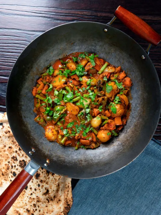 Overhead vegan vegetable bhuna Indian curry served in a wok.