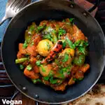 Overhead vegan vegetable bhuna Indian curry served a naan bread featuring a title overlay.