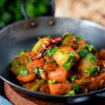 Vegan vegetable bhuna Indian curry served a naan bread.