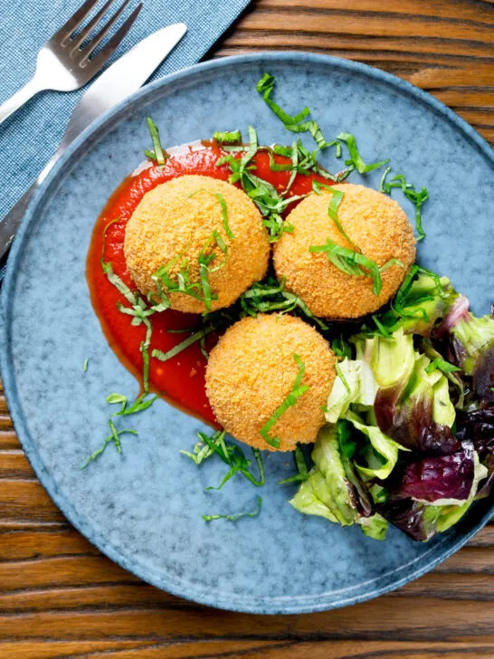 Overhead air fryer cooked arancini with an easy tomato sauce.