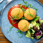 Overhead air fryer cooked arancini with an easy tomato sauce featuring a title overlay.